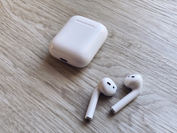 Detailný záber na AirPods a nabíjacie puzdro.